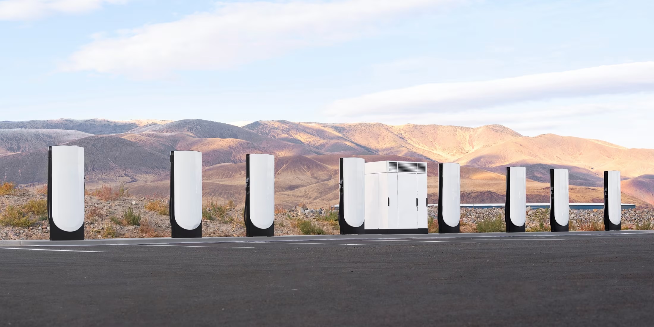 Eight Tesla V4 Supercharger posts flanking a single V4 cabinet